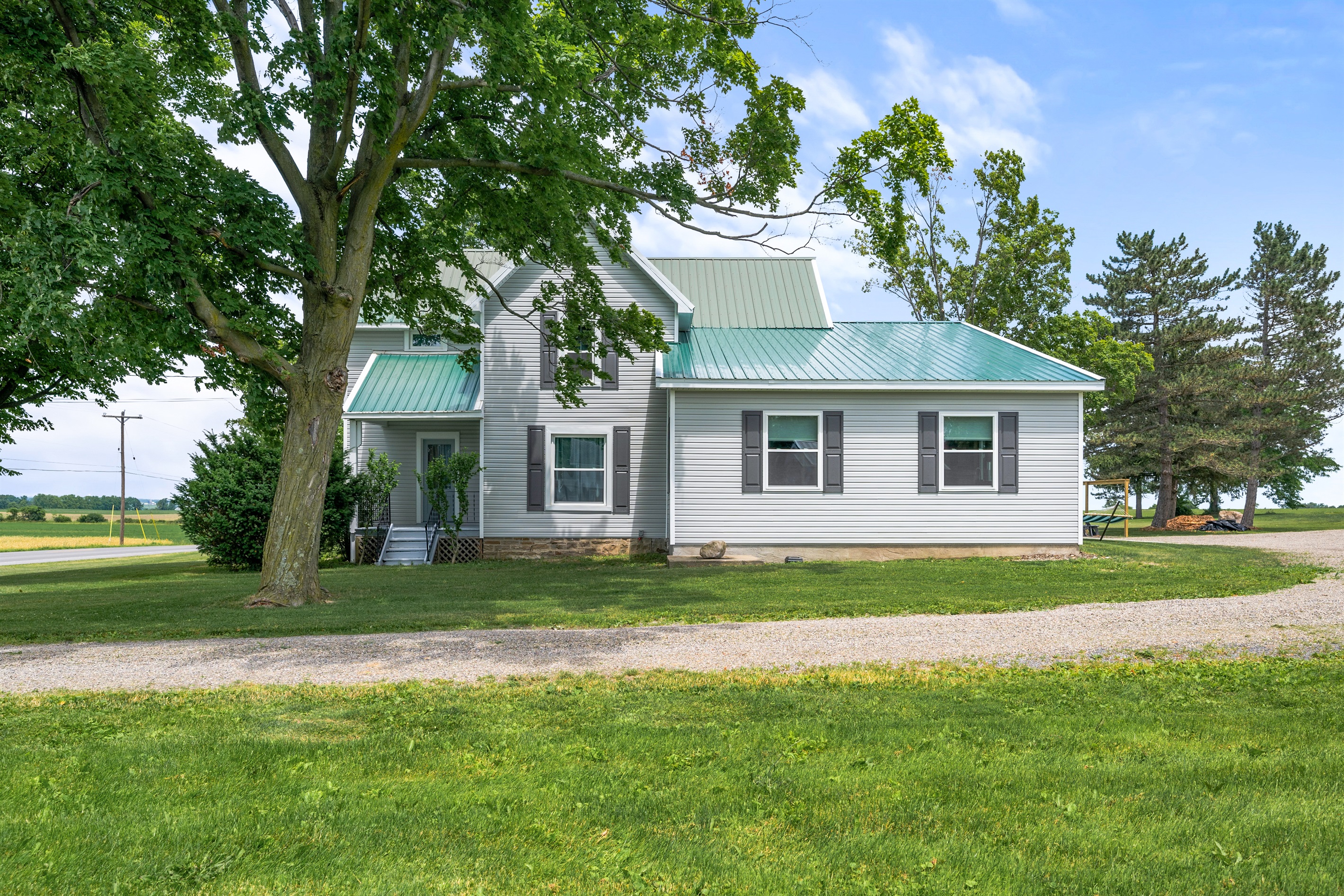 Charming farmhouse with classic curb appeal, surrounded by peaceful countryside views