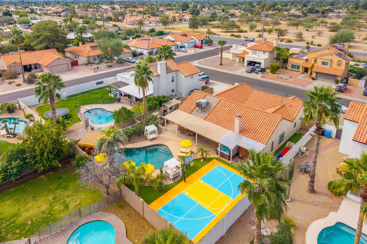 Aerial view of property with pools, sports courts, and desert mountain views—a premier Scottsdale vacation home with resort-style amenities.