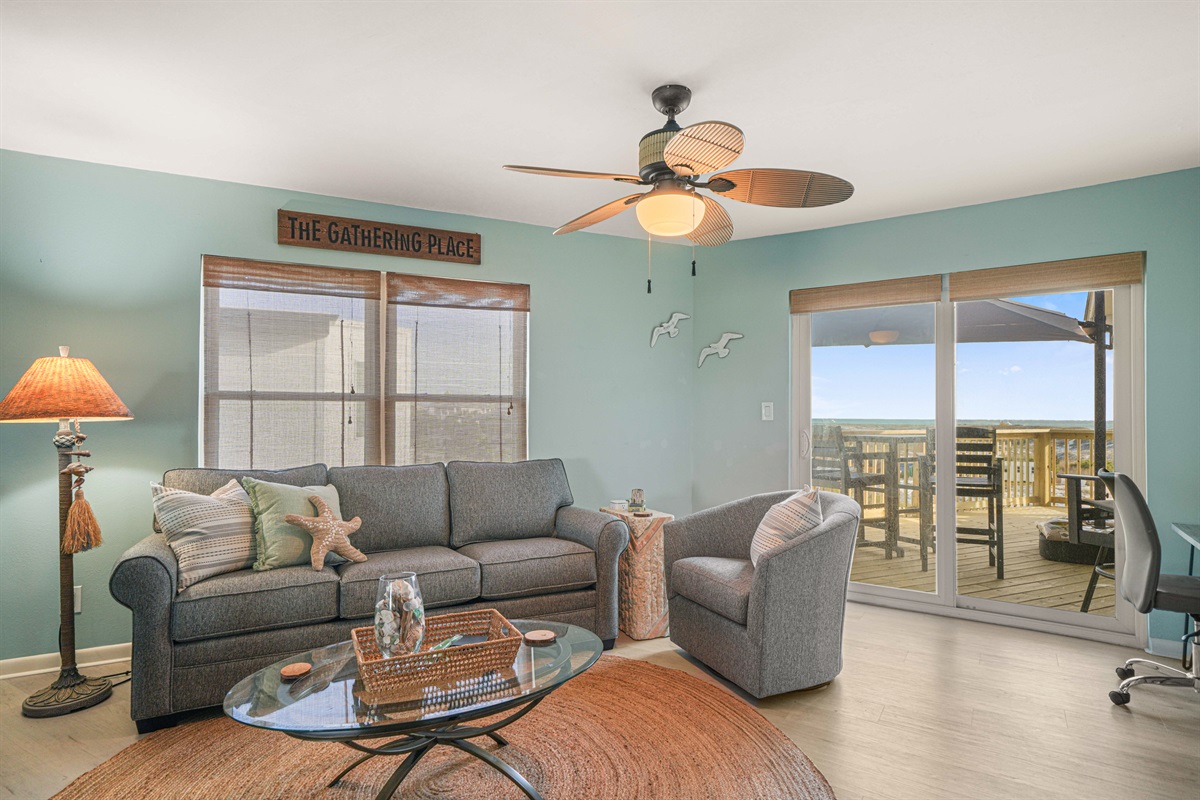 The living room opens directly to the deck. Queen sleeper sofa with an upgraded mattress — one of three sleeping areas. Sleeps 6.