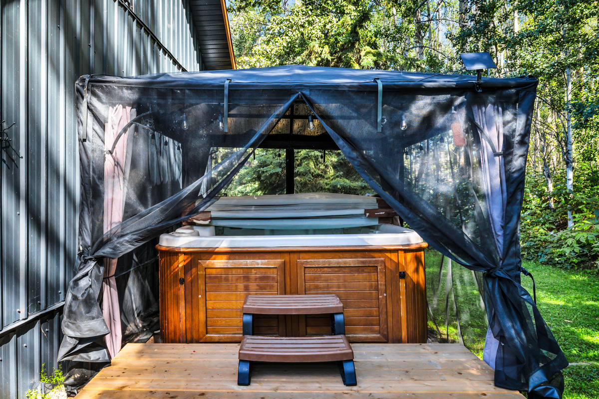 Enjoy the hot tub by day, tucked beside the cabin and surrounded by trees for a relaxing, private-feeling soak.