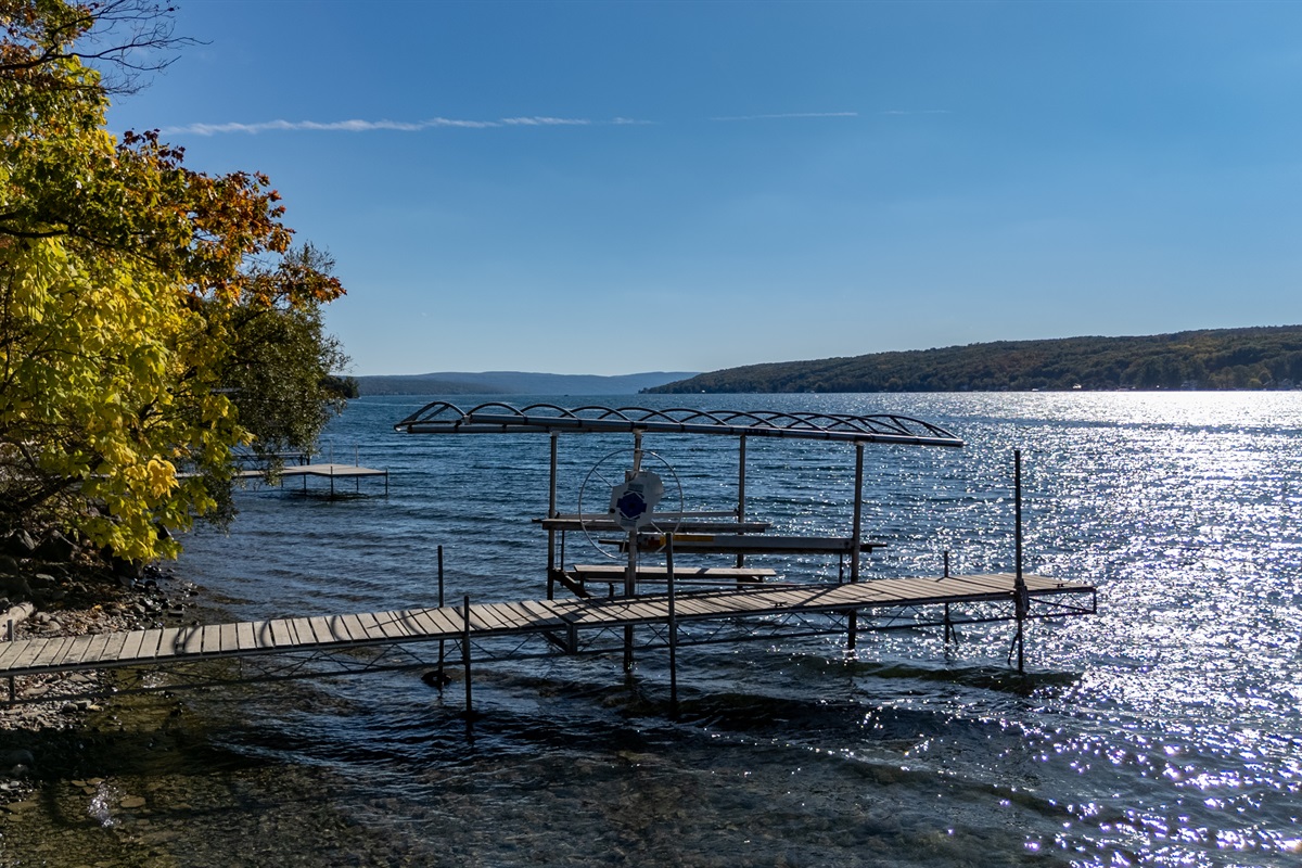 Dock extending into the sunlit lake — early morning or golden hour mood.