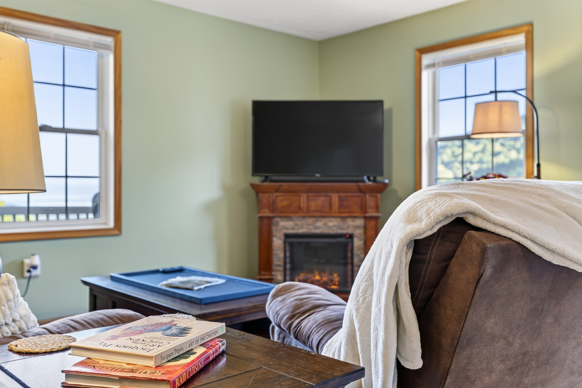 The living room is cozy with plenty of blankets and throws and some games in the coffee table storage drawers.