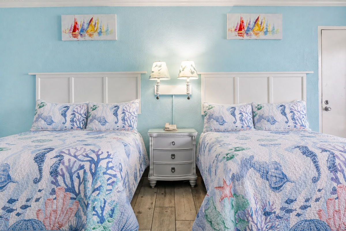 Two beds, twin reading lamps, and a nightstand made for late-night chats. ⭐