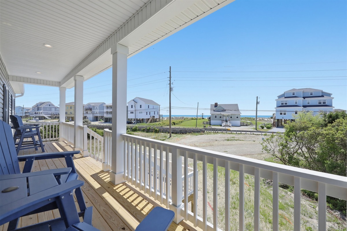 Covered front porch with seating and peekaboo ocean views&mdash;perfect for morning coffee or sunset unwinding