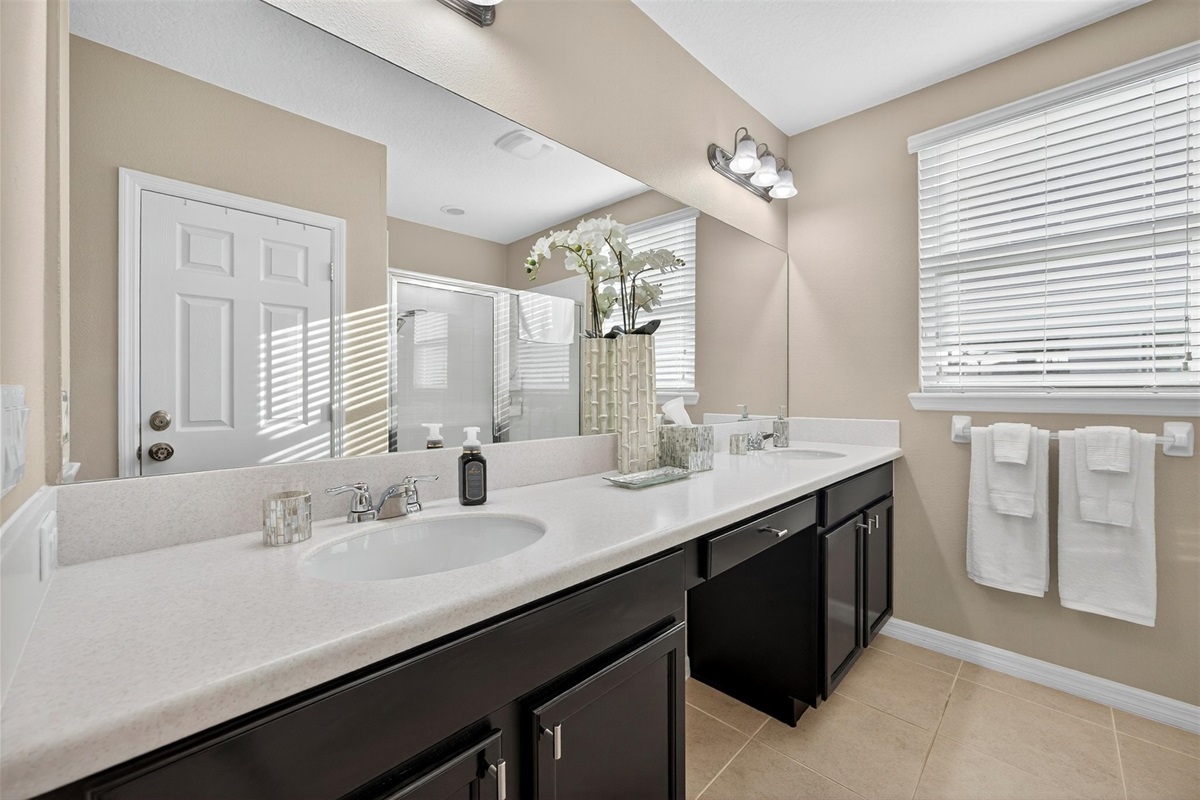 Spacious ensuite bathroom with dual sinks and large mirrors.