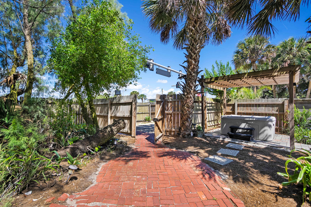 A brick path threads between the planting to the patio, where the grill waits under the pergola. Carry out the plates, claim a chair, and let dinner stretch on until the light goes soft and gold over the top of the fence.