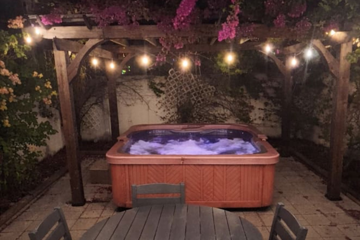 Evening hot-tub retreat under bougainvillea and string lights. “No place we’ve ever stayed has been quite as delightful as the Ybor Roost. One of a kind!” — Guest review