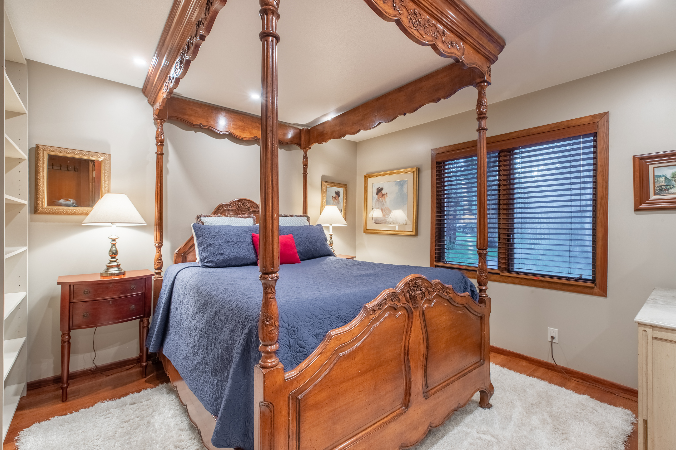 Elegant West bedroom with dresser, bookcase, Roku television, en suite bath, and four-poster Queen bed