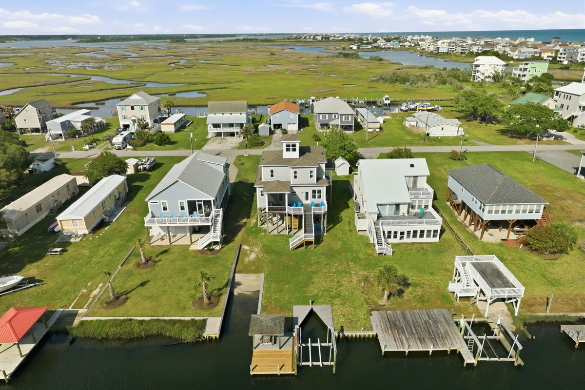 Waterfront aerial showcasing the private dock, boat lift, and spacious backyard setup