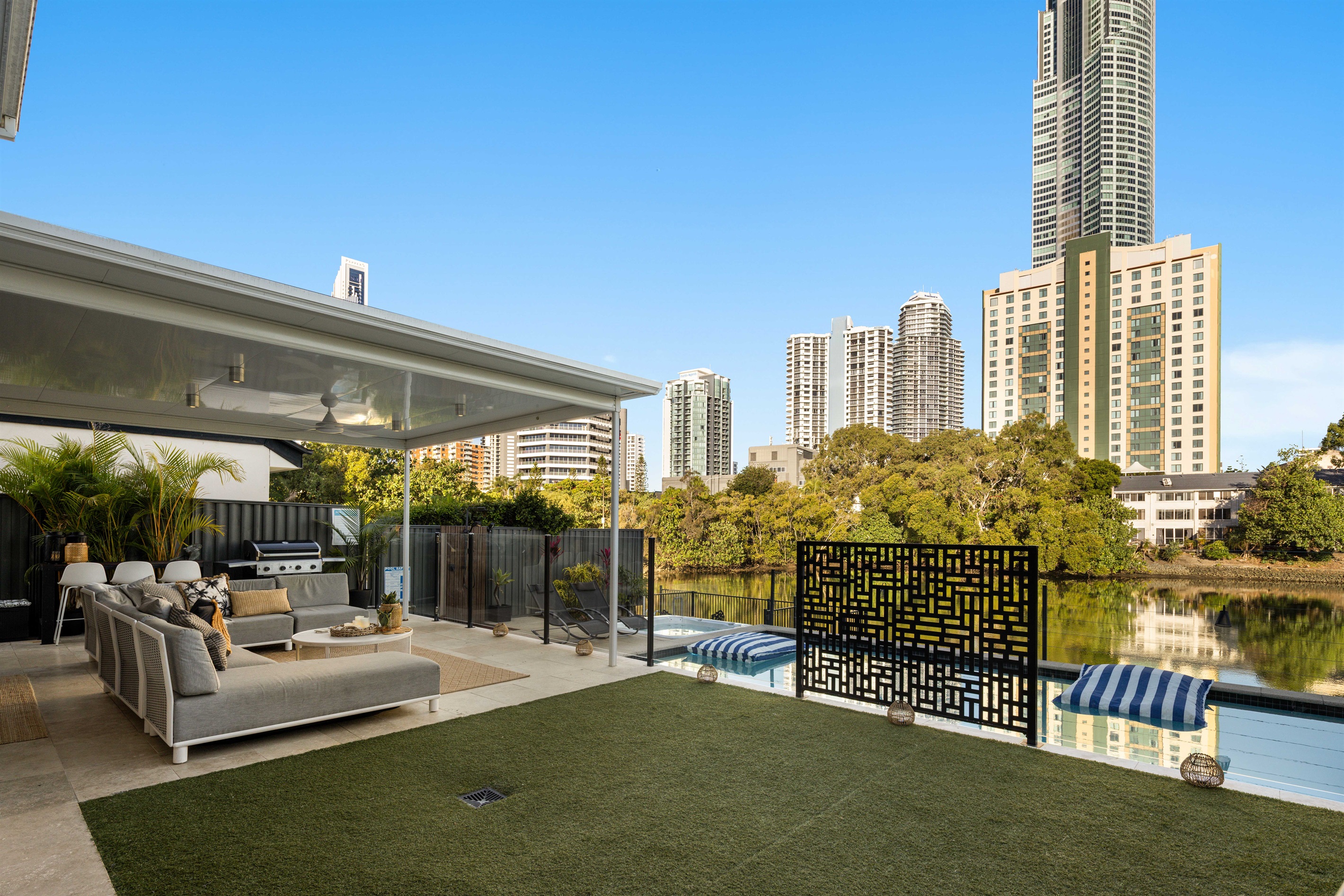 Private waterfront setting with open lawn space and seamless indoor–outdoor flow.