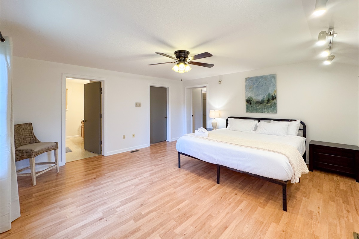The master bedroom features a king size bed, large space, closet, and ensuite bathroom with accessibility features. 