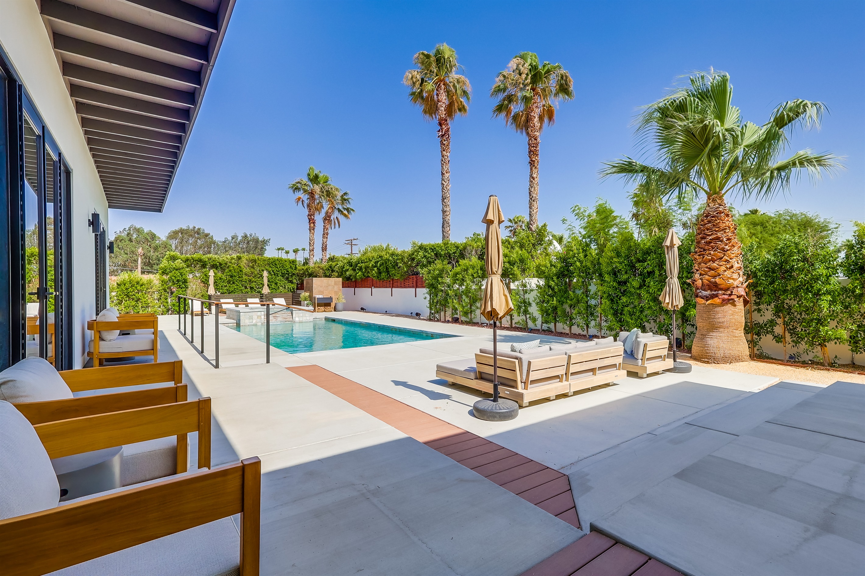 Outdoor space with several seating areas, pool chaise loungers