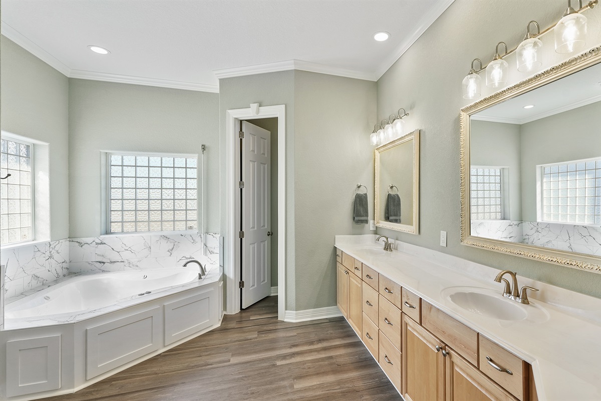 Spa-like master bathroom with double vanity and plenty of space to prepare for beach days or evening outings.