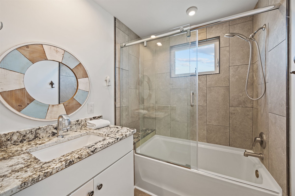 Bright upstairs bathroom with tub and glass shower combo