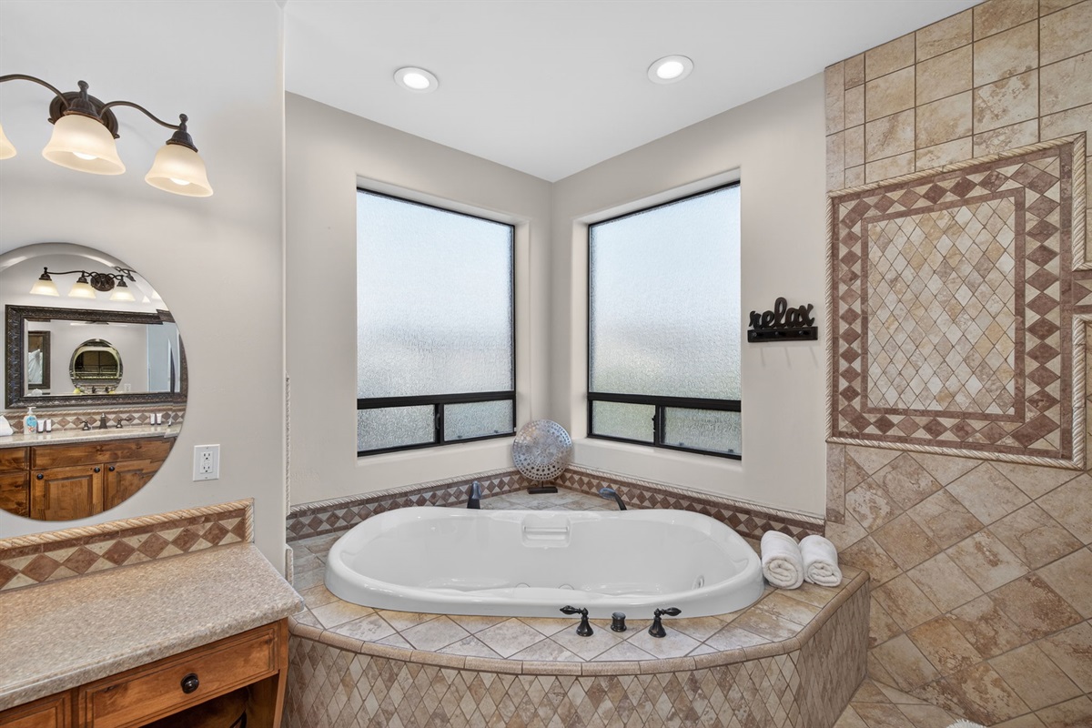 Large soaking tub beside oversized windows creates a peaceful place to unwind after a day of exploring Phoenix