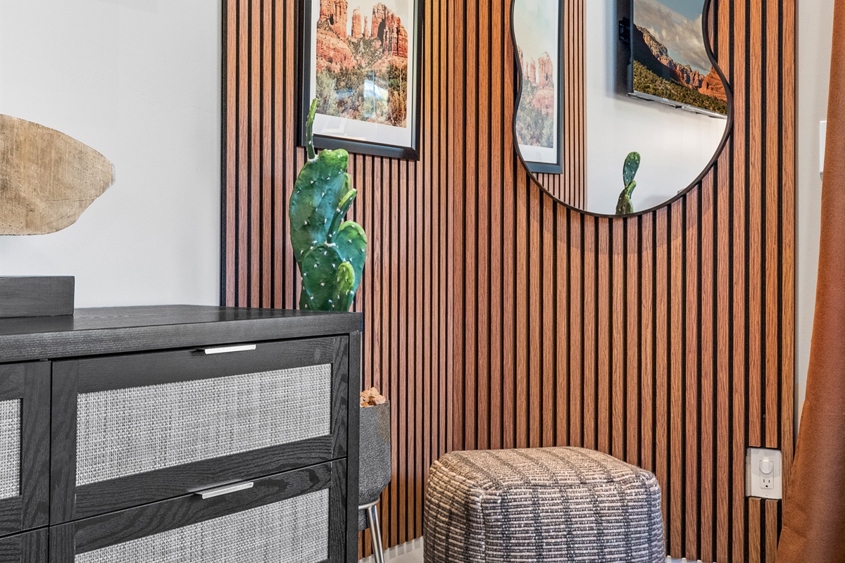 Warm wood textures, local artwork, and curated accents add character and a calm, grounded feel to the bedroom.