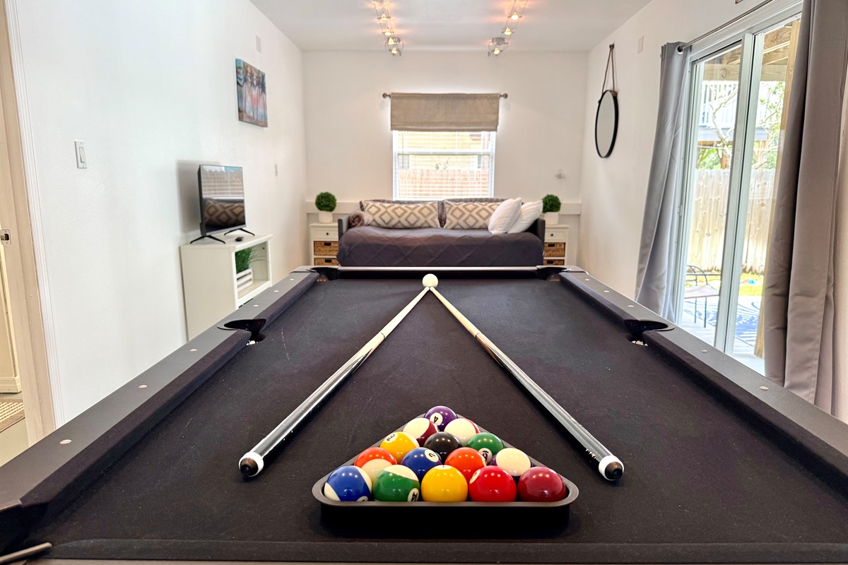 Spacious game room with full-size bed and direct patio access.