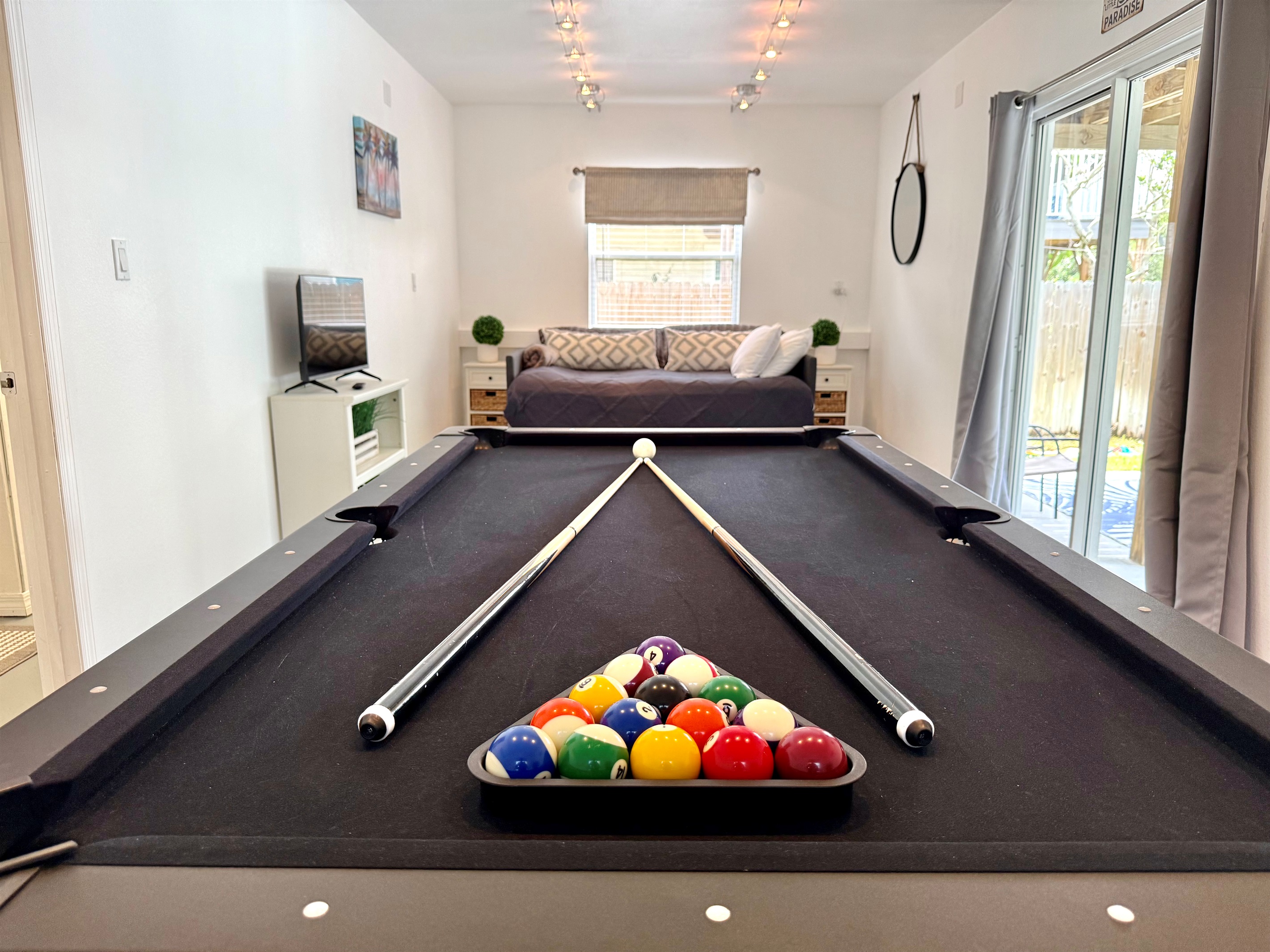 Spacious game room with full-size bed and direct patio access.