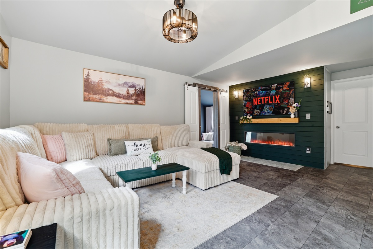The perfect combination: A cozy sofa, a smart TV, and the fireplace crackling away. 