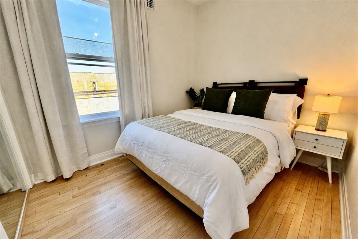 Bright bedroom with comfortable bed and natural sunlight.