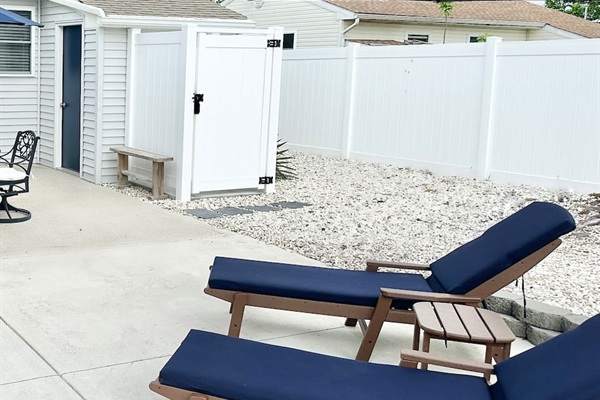 Rinse off after a day at the beach in our private outdoor shower, conveniently located right off the patio. This sun-soaked backyard area also features comfortable navy lounge chairs and a clean, fenced-in space for your privacy and relaxation.