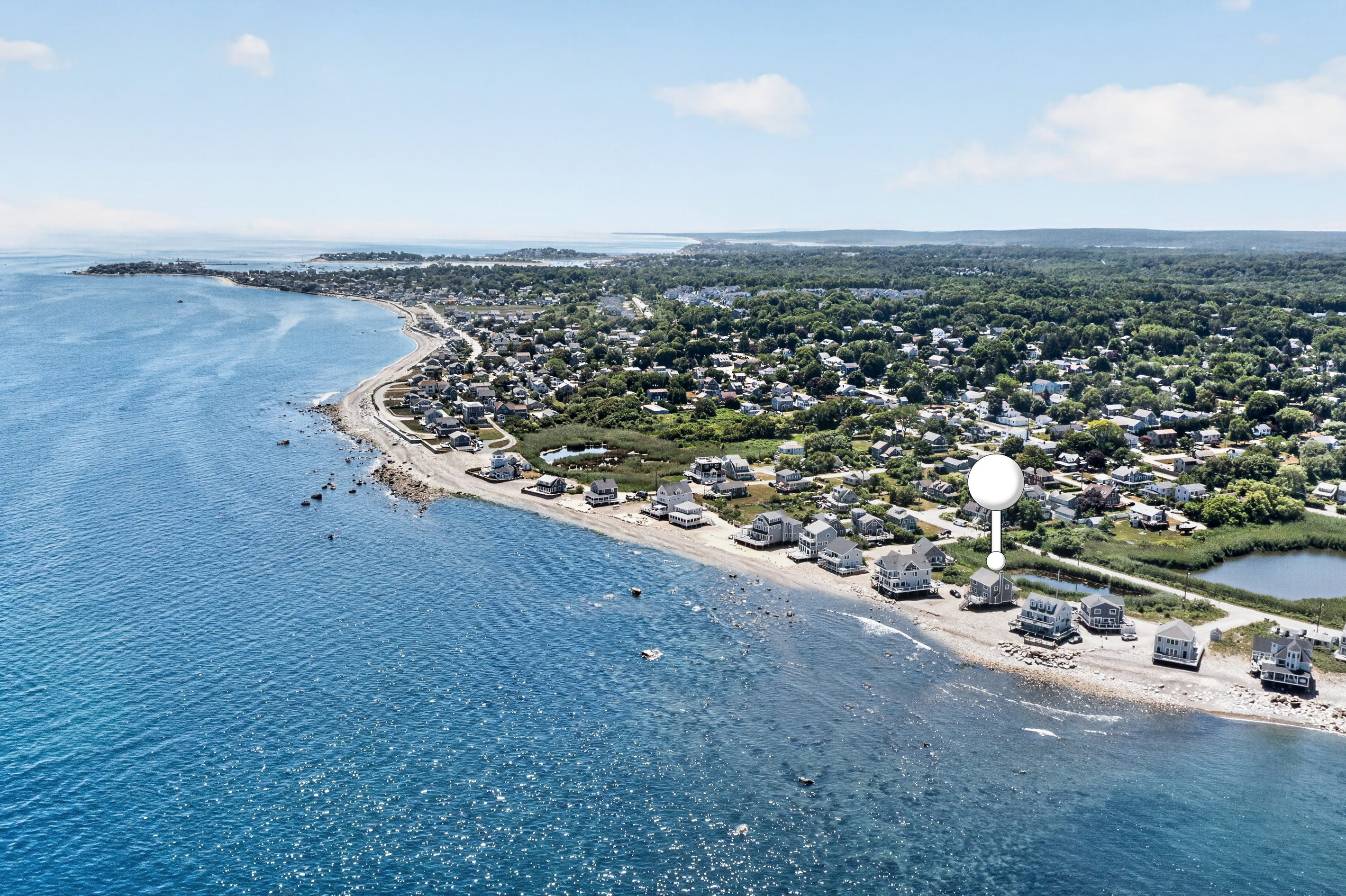 Aerial perspective highlights the sweeping coastline and the home’s prime location near the water.