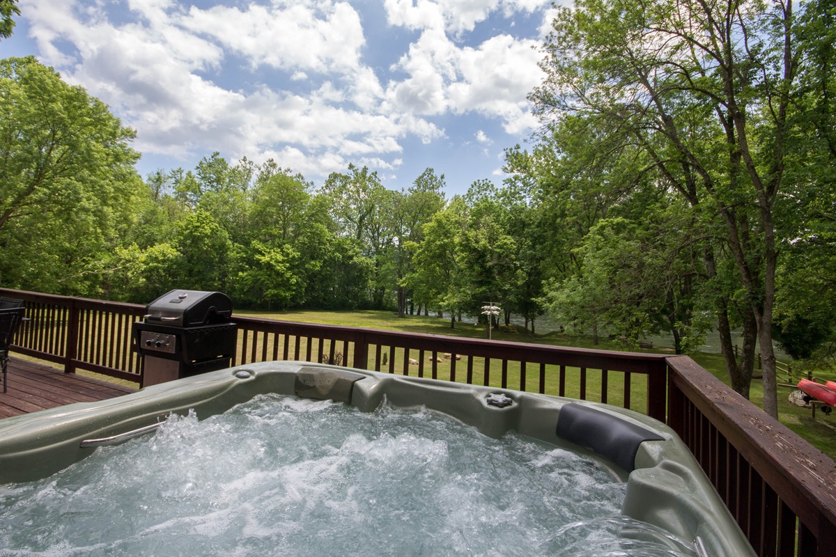 Modern hot tub, with lots of jets and bubbles, overlooking the lawn and river