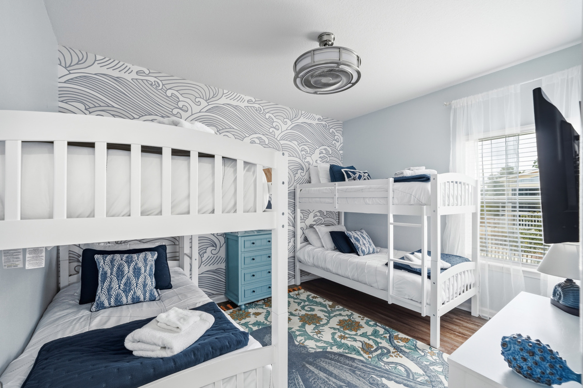Cozy twin bunk beds provide a comfortable and playful space where kids and friends can relax after a day at the beach