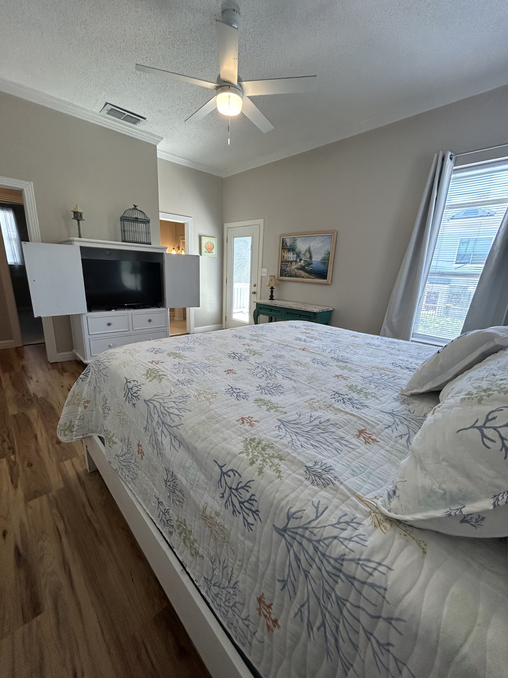 King Suite featuring an ensuite bath and balcony access with views of the lushly landscaped backyard oasis below. A twin rollaway bed is available to accommodate an additional guest, with ample space to position it comfortably at the foot of the bed.