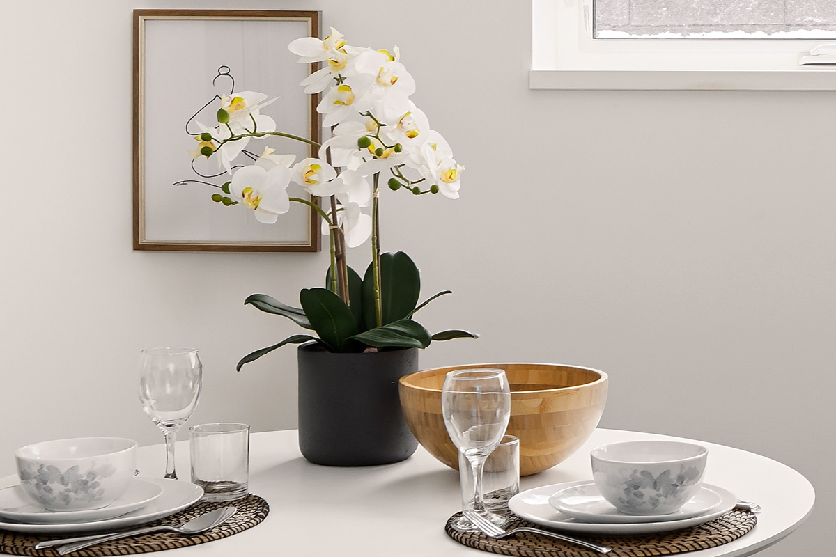 Simple, Scandinavian-style dining setup with dishware provided for everyday meals.