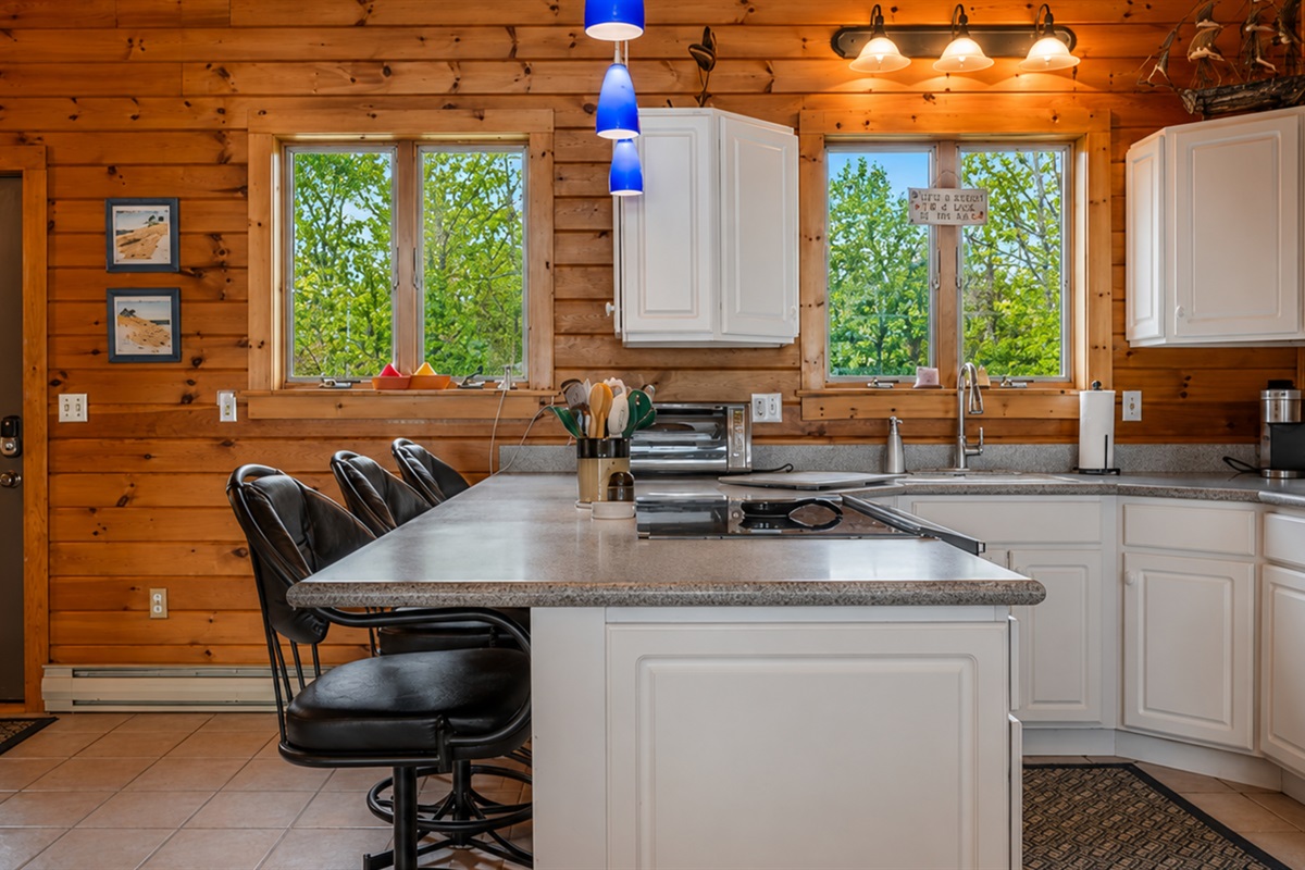 Enjoy a spacious and modern kitchen with sleek black bar stools, perfect for casual dining and socializing.