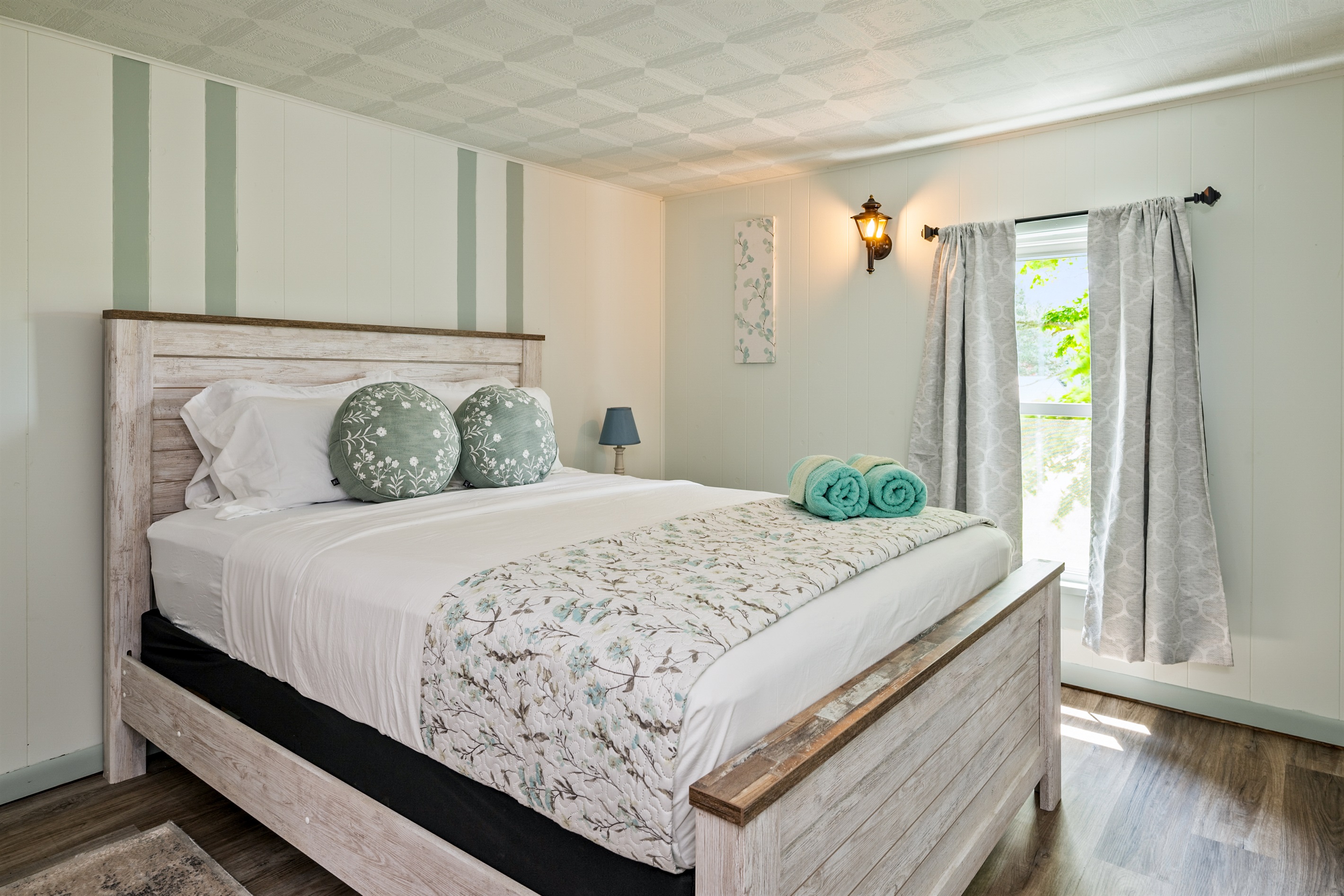 Relax in this serene bedroom featuring cozy floral accents, soft lighting, and peaceful views—perfect for a restful night's sleep.