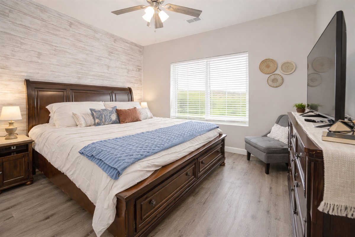 Relax in this spacious king bedroom featuring a cozy layered bed.