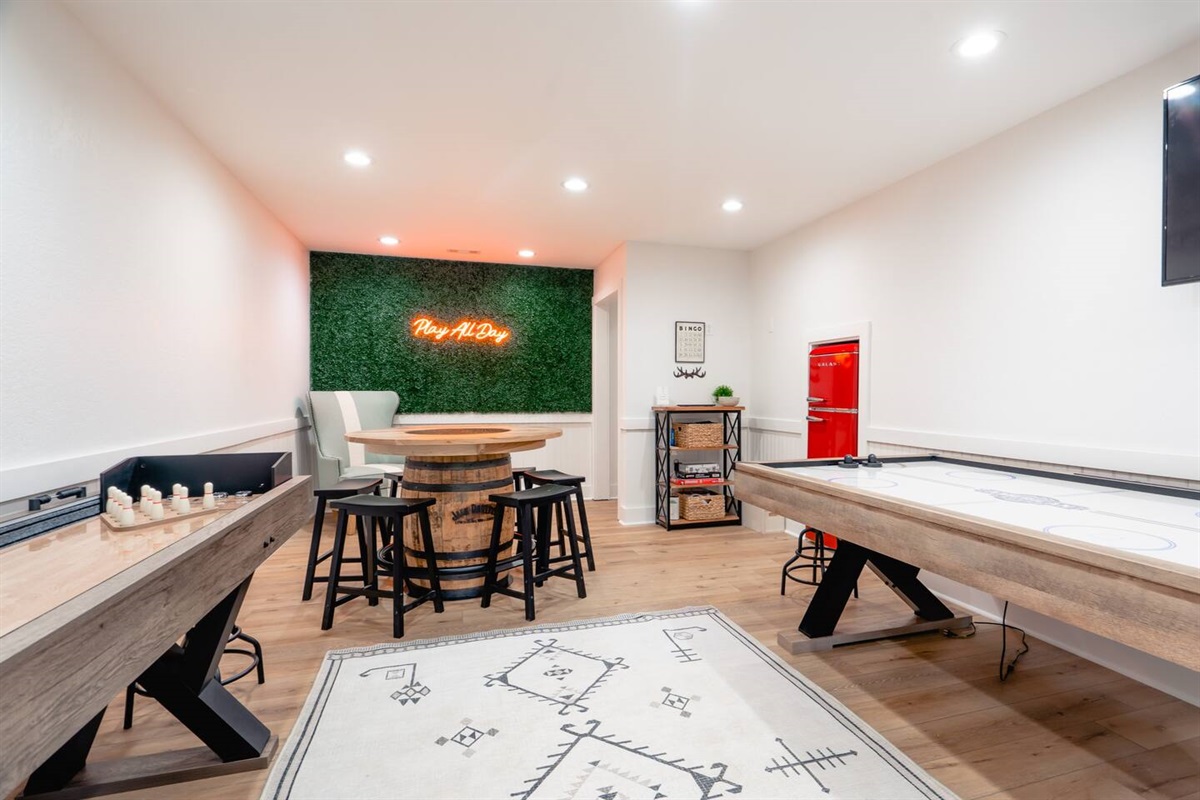 Game room with air hockey, shuffle board, arcade set, and foosball