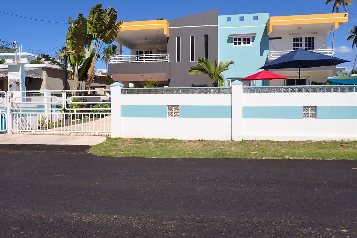 Entrance to the second floor unit with vibrant colors and inviting shady umbrellas welcome you to your perfect getaway!