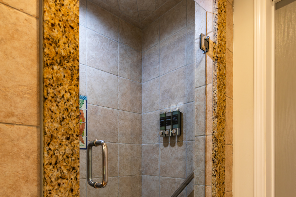 A spacious tiled walk-in shower adds convenience to the upstairs common bathroom.