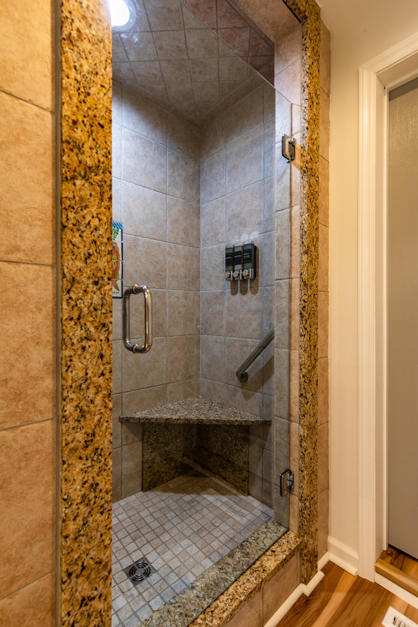 A spacious tiled walk-in shower adds convenience to the upstairs common bathroom.