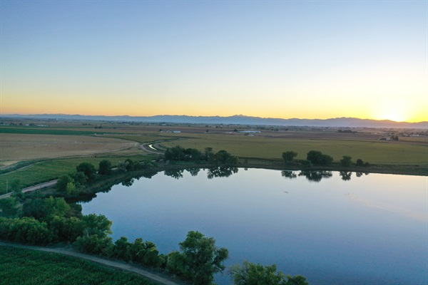 Golden sunlight illuminating the surrounding farmland, with the lake and it's natural beauty.