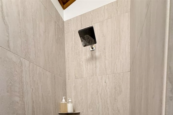 Newly renovated walk in shower with a river rock tile floor. 