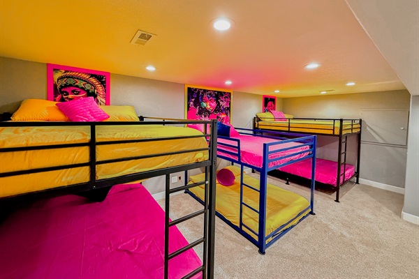 Massive bedroom featuring 2 queen-sized and 1 full-sized bunk beds, perfect for groups or families to stay in comfort