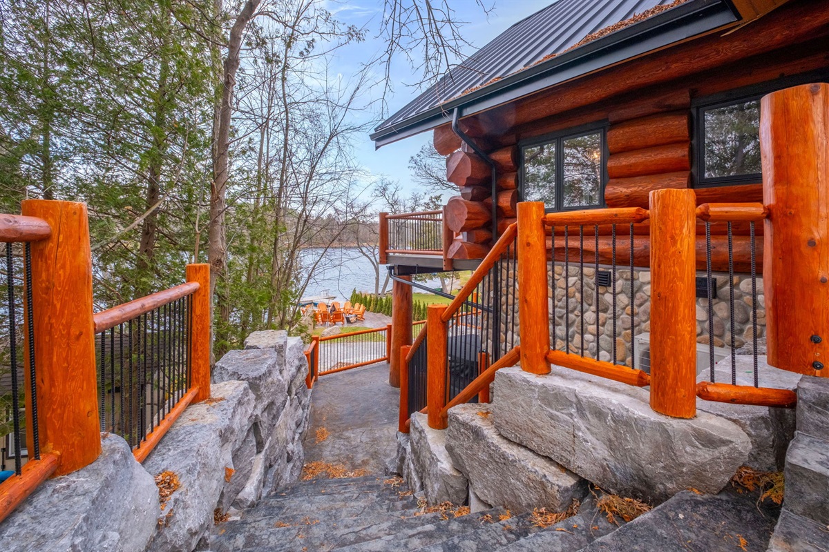 Stone pathway leading from the lodge to the waterfront firepit and dock — beautifully landscaped and illuminated.