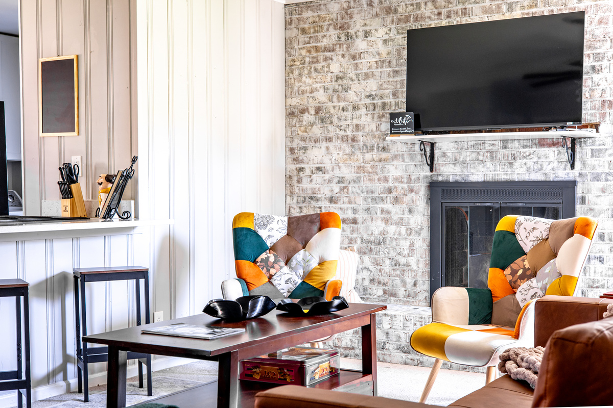 Living room that opens to the kitchen. Plenty of seating, decorative fireplace, TV
