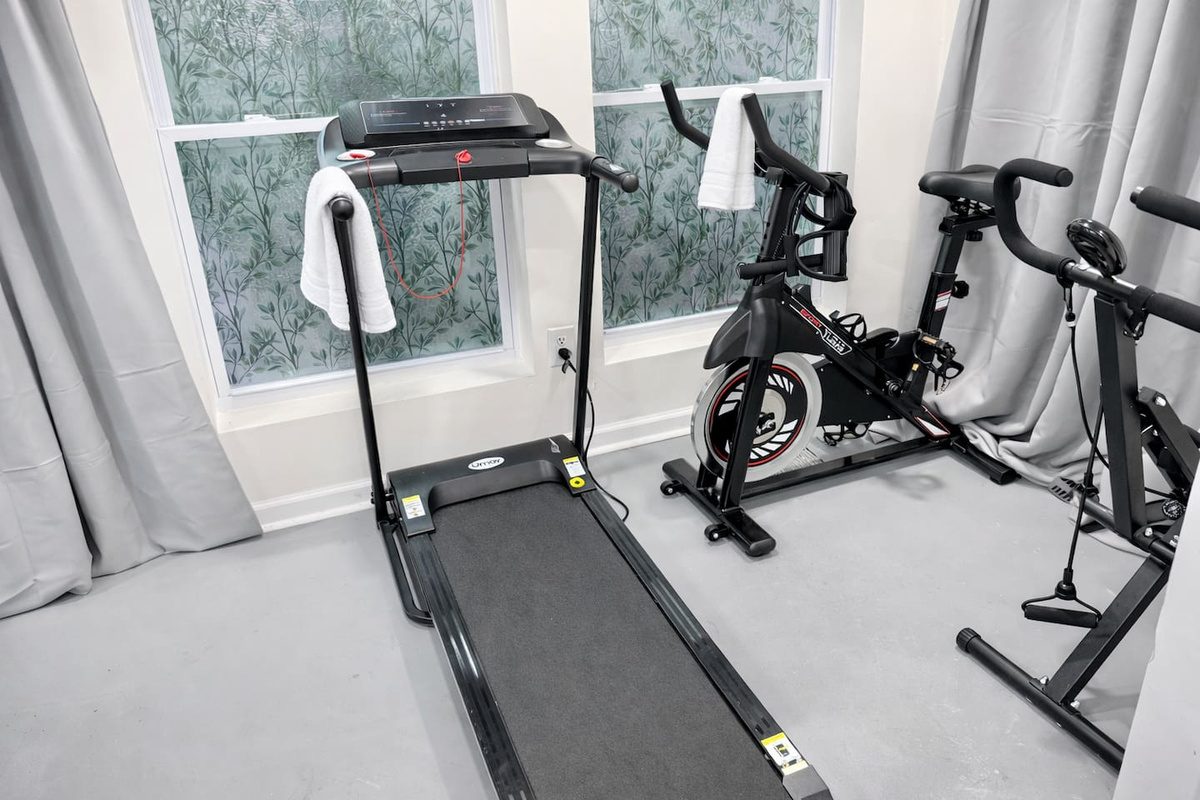 Gym equipment available including a treadmill, stationary bike, & squat machine.