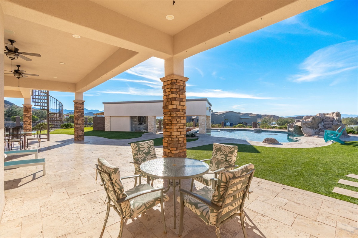 Outdoor dining area beside the lawn and pool offers a beautiful setting for meals under the Arizona sky