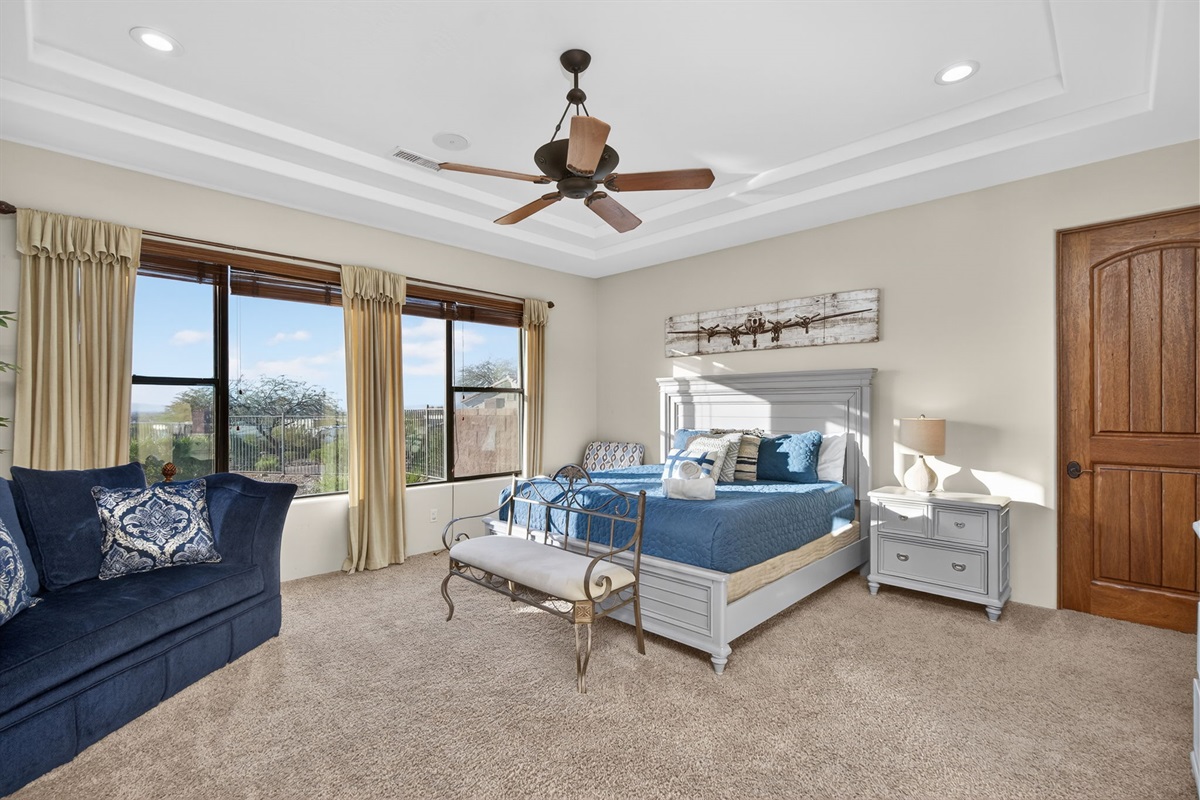 Bright king bedroom retreat with large windows and peaceful desert views — ideal for relaxing after a day in the sun