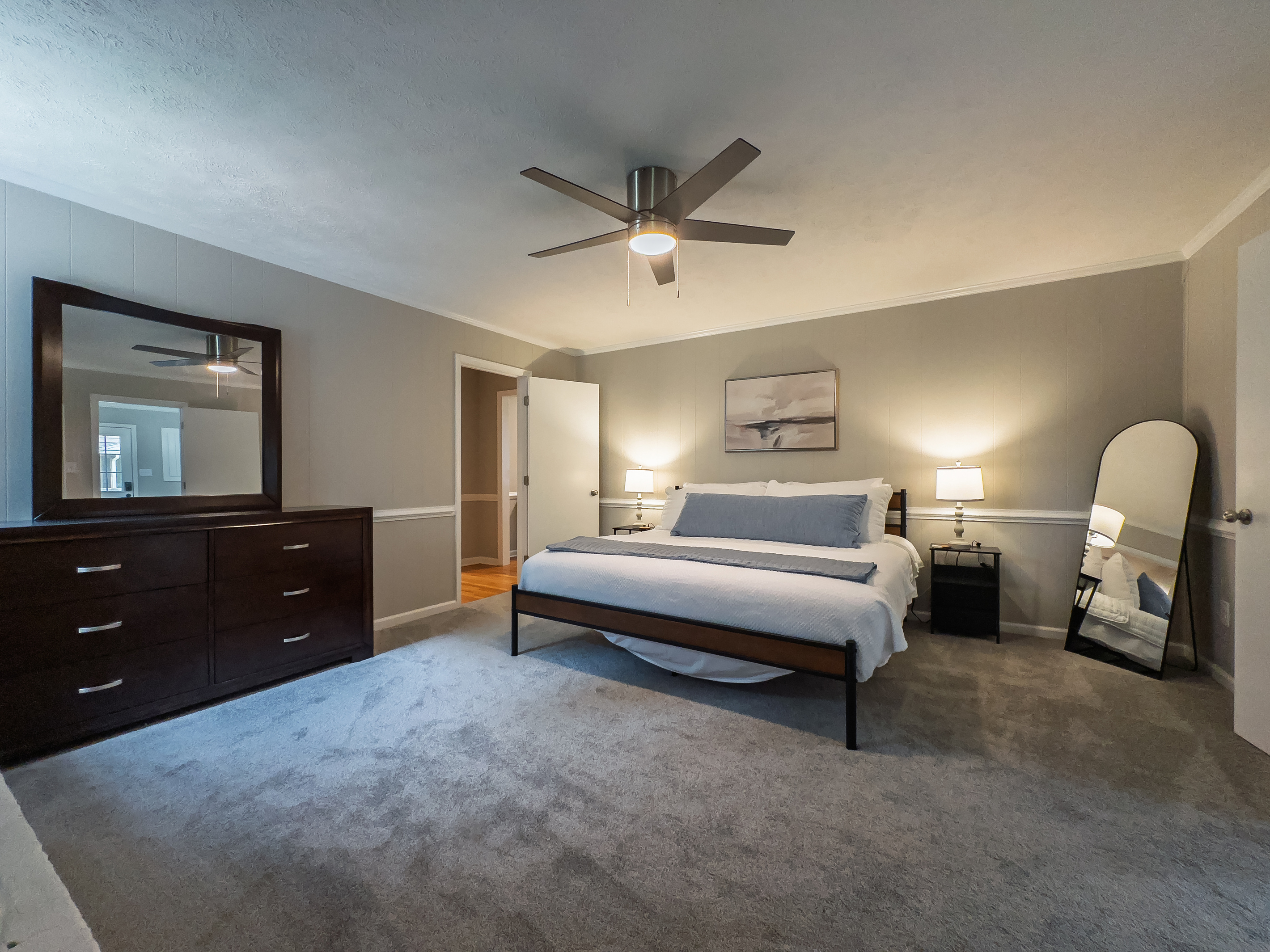 King bed, 55" Smart TV, ceiling fan, two led light nightstands with multiple charging ports, two multi light function lamps, blackout curtains, dresser, wardrobe closet, full length mirror, stylish brick fireplace - not in use.