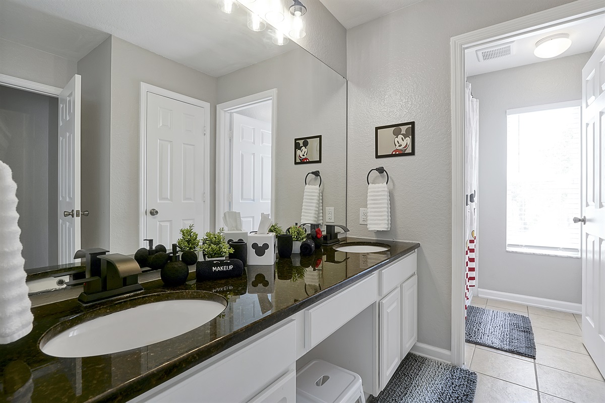 The upstairs Mickey themed shared full bathroom serves the Peter Pan, Encanto, and Mickey Mouse rooms. Double vanity, tub and shower, and seperate toilet room provide lots of space for guests big and little to get ready in.