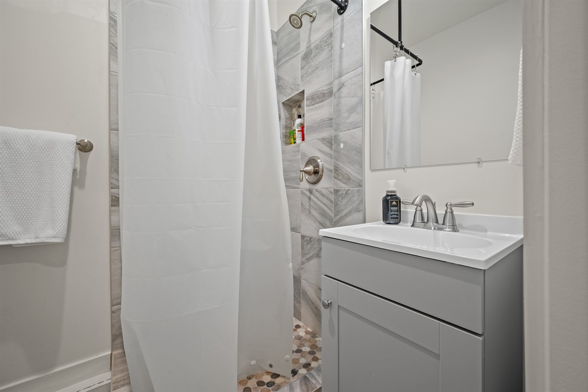 Bright and stylish studio bathroom with walk-in shower and modern fixtures