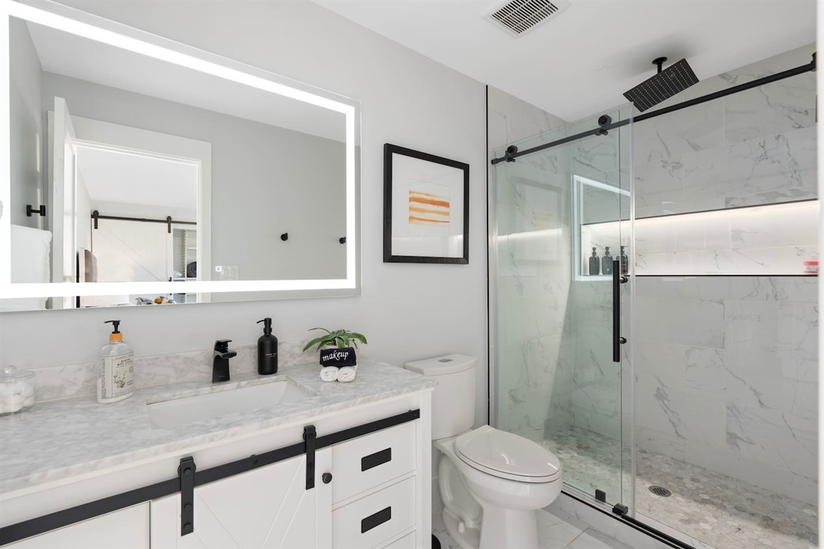 Bright and modern bathroom featuring a glass-enclosed shower, minimalist decor, and clean lines throughout.

