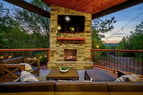 Cozy up by the outdoor stone fire for a movie night under the stars.